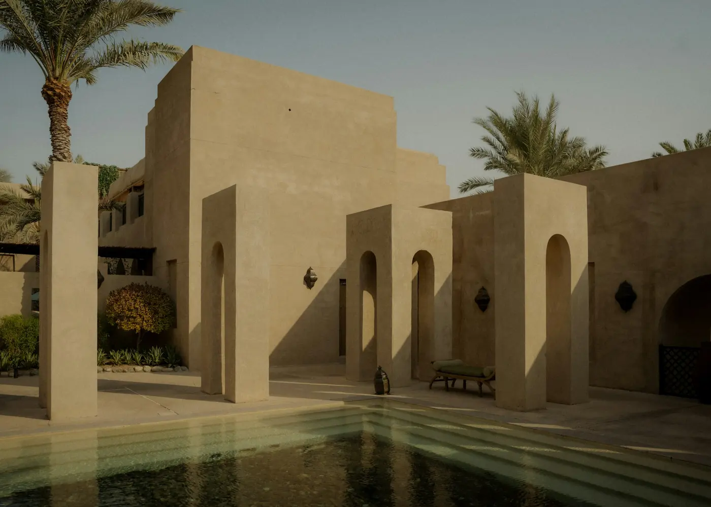 A sandstone courtyard with a shaded pool